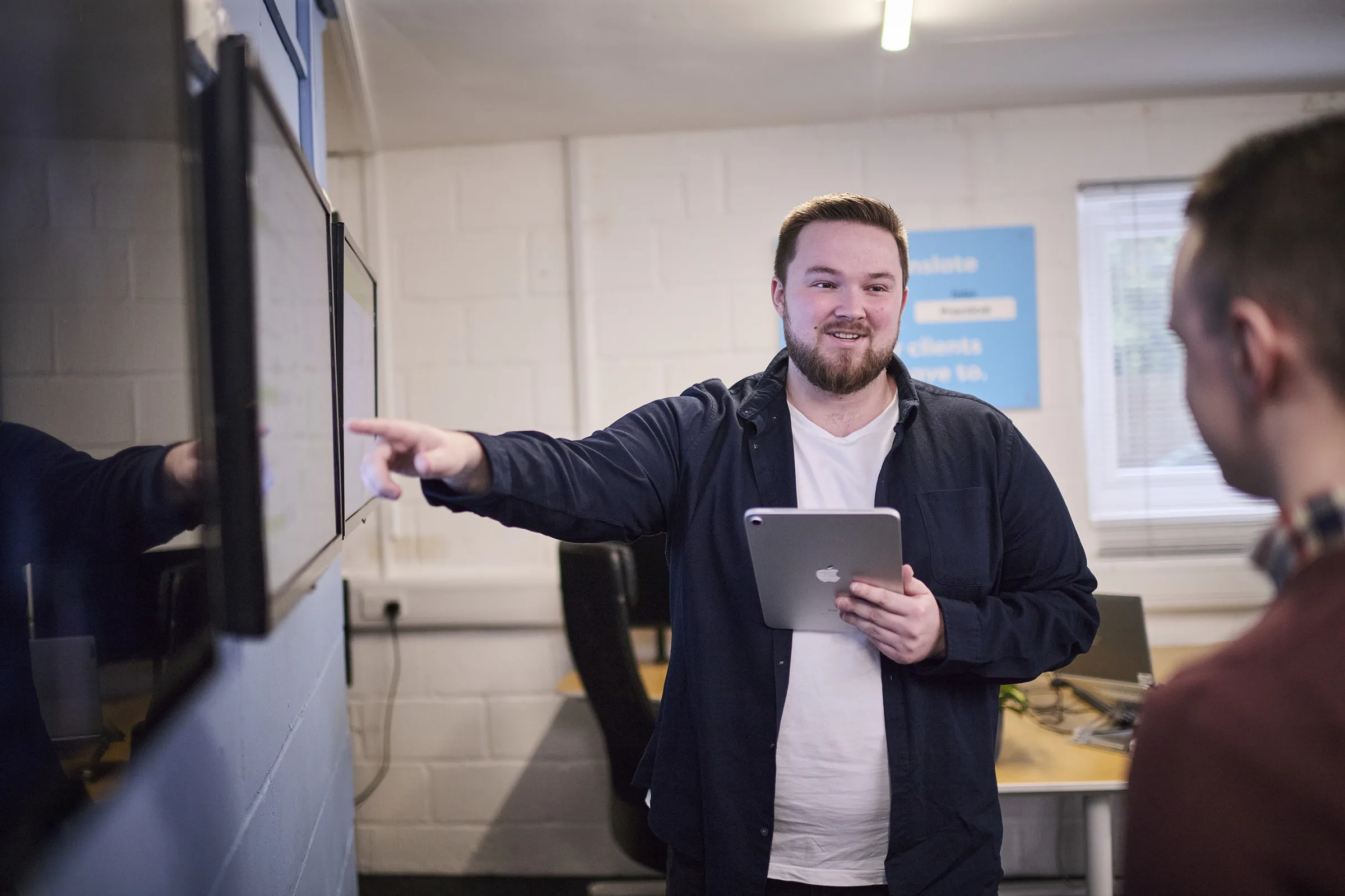 Osiris consultant discussing a workflow prototype with colleagues around a tablet.